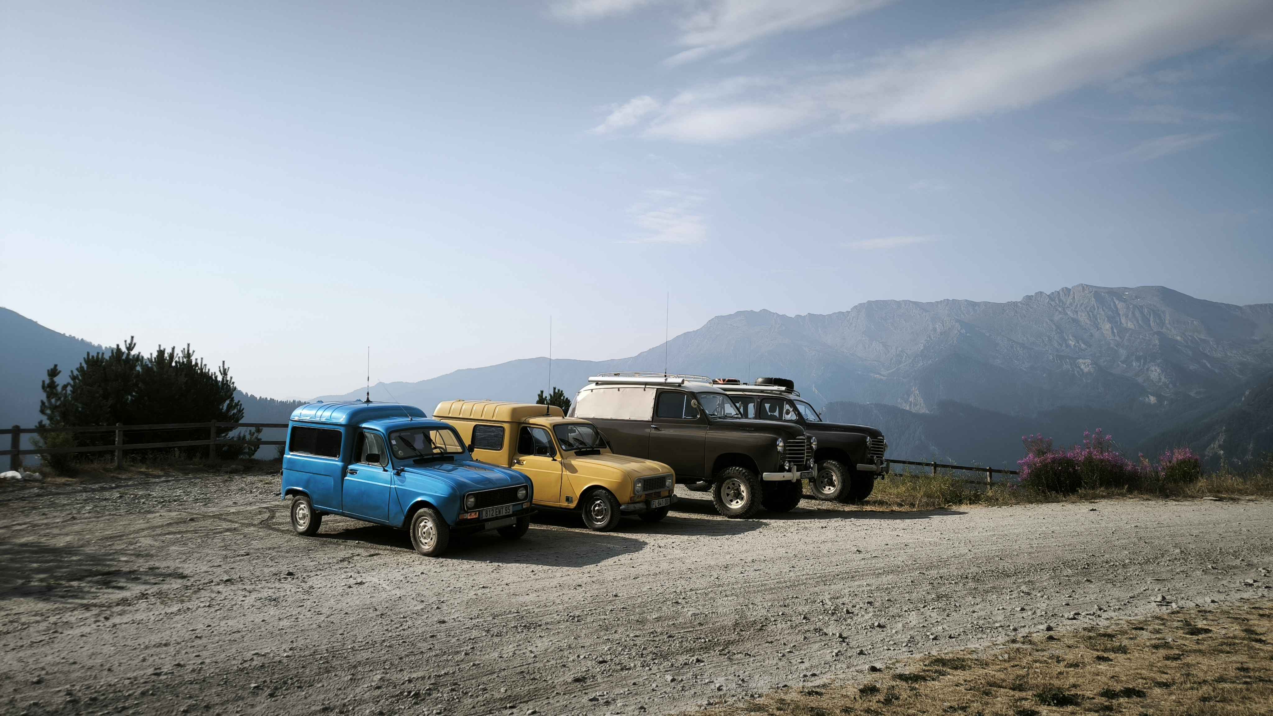 Les véhicules du raid devant les montagnes des Alpes
